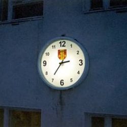 Lempäälän vaakunalla ja selkeillä numeroilla varustettu viisarikello asennettuna koulun seinään - RWM-Systems.