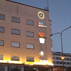 Koteloimaton ledein valaistu viisarikello avoimin viisarein kiinteistön julkisivulla Vaasan torilla - RWM-Systems.